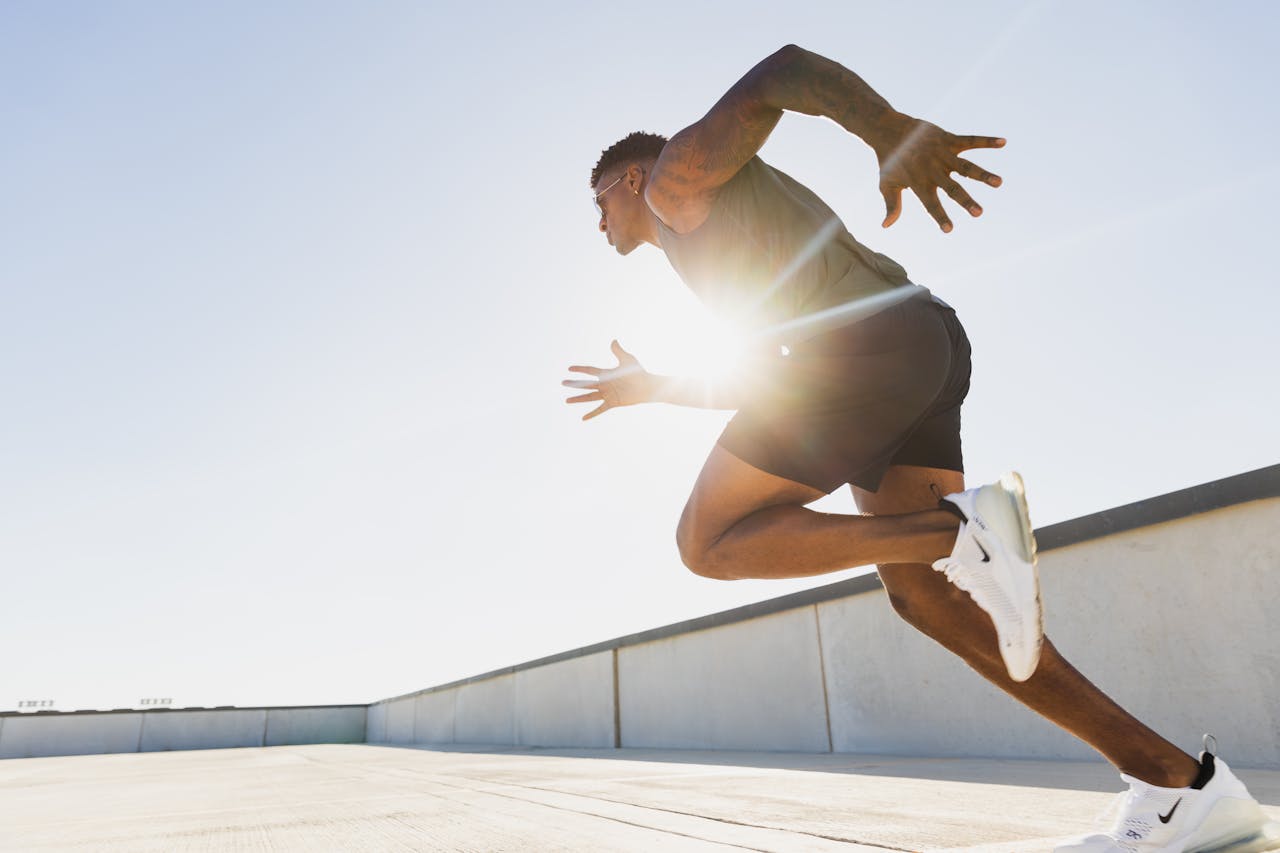 about-01 Dynamic side profile of an athletic man sprinting on a rooftop in Austin, Texas at sunrise.